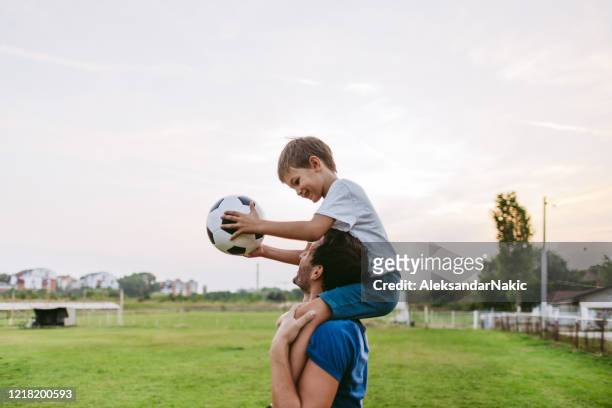 lächelnde fußballspieler - sportbegriff stock-fotos und bilder