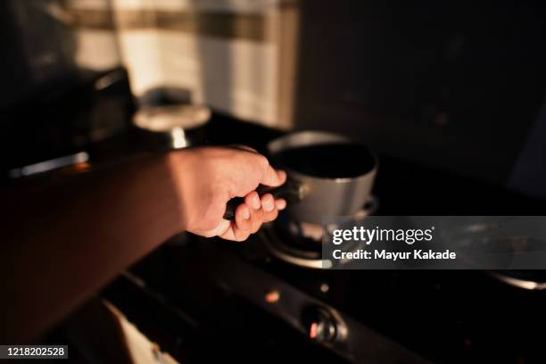 personal perspective of a man making tea at home - cooker stock pictures, royalty-free photos & images