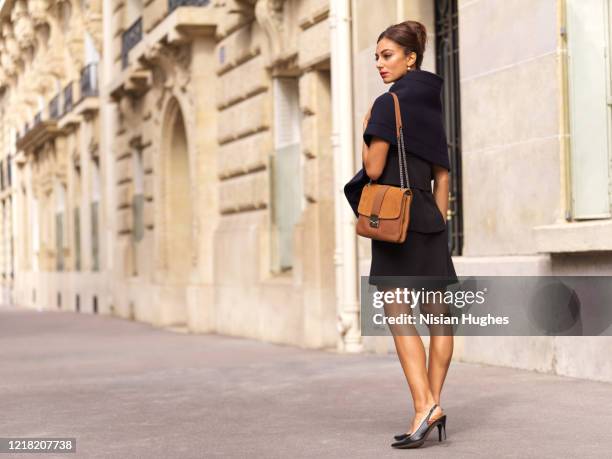 stylish young woman with purse daytime, paris france - brown purse stock-fotos und bilder