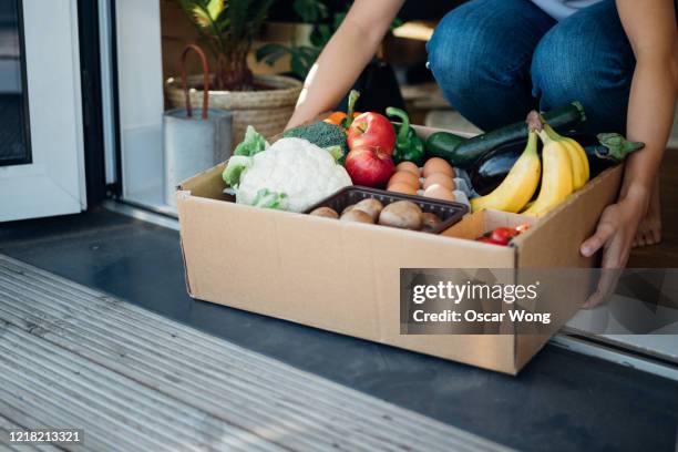 young woman receiving fresh food home delivery - delivery food bildbanksfoton och bilder