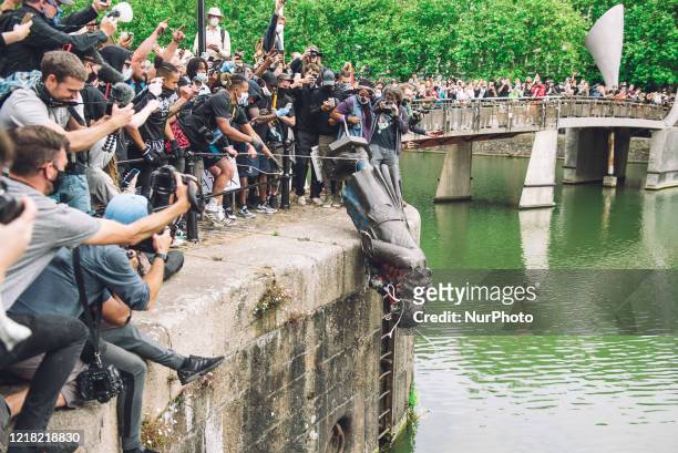 The statue of Colston is pushed into the river Avon. Edward Colston was a slave trader of the late 17th century who played a major role in the...