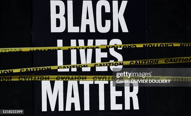 Black Lives Matter" placard is seen behind caution tape during a peaceful protest against police brutality and the death of George Floyd, on June 7,...