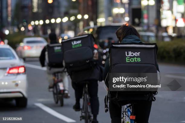 Uber Eats delivery men ride bicycles through the Kabukicho entertainment area on April 11, 2020 in Tokyo, Japan. Tokyo Governor Yuriko Koike has...