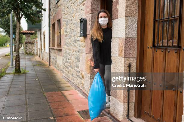 going outside to throw a trash bag - holding garbage bag stock pictures, royalty-free photos & images