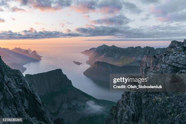 piccola figura di persona che fa escursioni in montagna sull'isola di senja nella nebbia - isola di senja foto e immagini stock