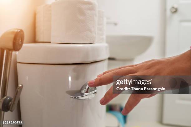 cropped hand of man flushing water - human toilet 個照片及圖片檔