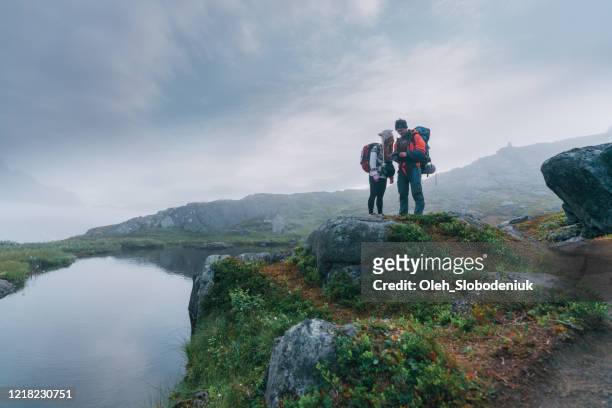 man en vrouw die in berg op eiland senja wandelen - lofoten en vesterålen stockfoto's en -beelden