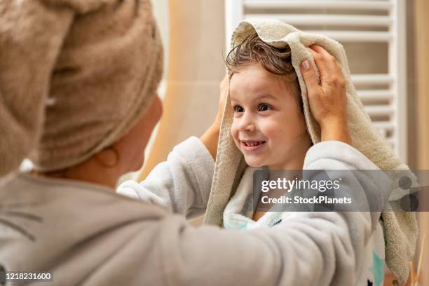 la madre sta asciugando la testa del ragazzo - asciugare foto e immagini stock