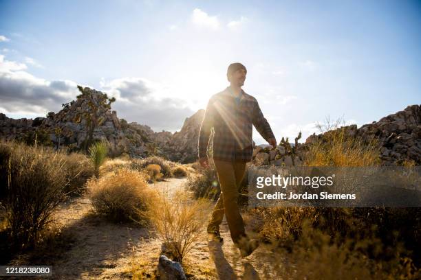 a man hiking a scenic trail in the desert. - mid adult stock-fotos und bilder