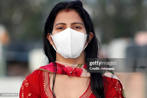 mujeres cubriendo su rostro con máscara de contaminación para protegerse de virus como covid-19 - máscara quirúrgica fotografías e imágenes de stock