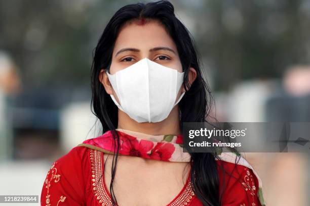 women covering her face with pollution mask for protection from viruses like covid-19 - covid 19 mask stock pictures, royalty-free photos & images