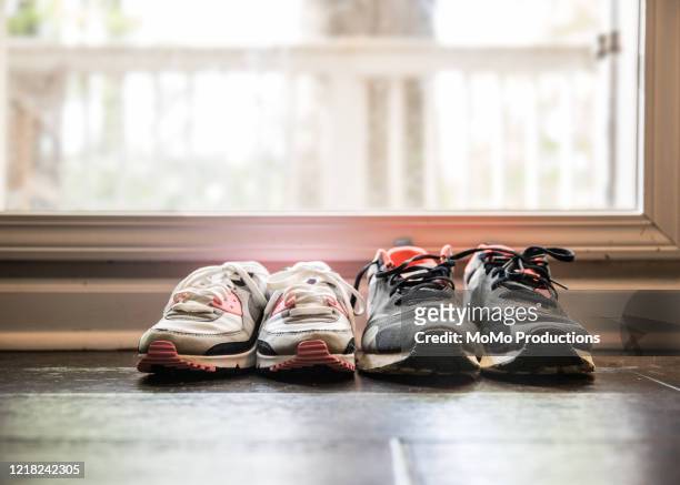 still life of different size shoes on floor at home - sports shoe stock-fotos und bilder