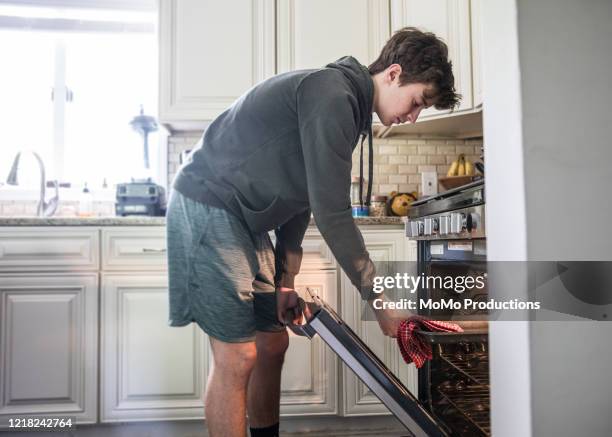 teenage boy cooking in kitchen - boy looking up stock pictures, royalty-free photos & images