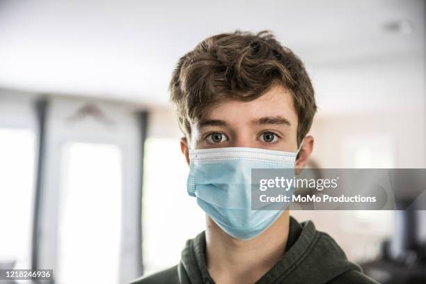 teenage boy wearing surgical mask - griepmasker stockfoto's en -beelden
