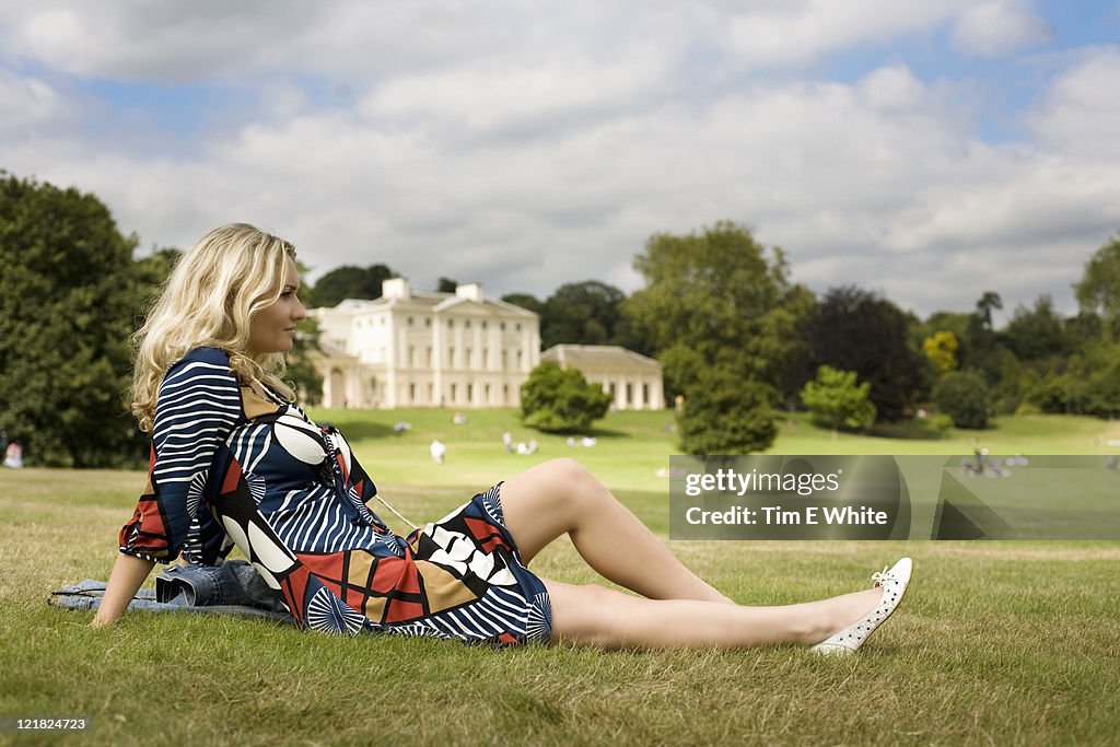 Woman lying on the grass in front of Kenwood House, Hampstead Heath, London, UK