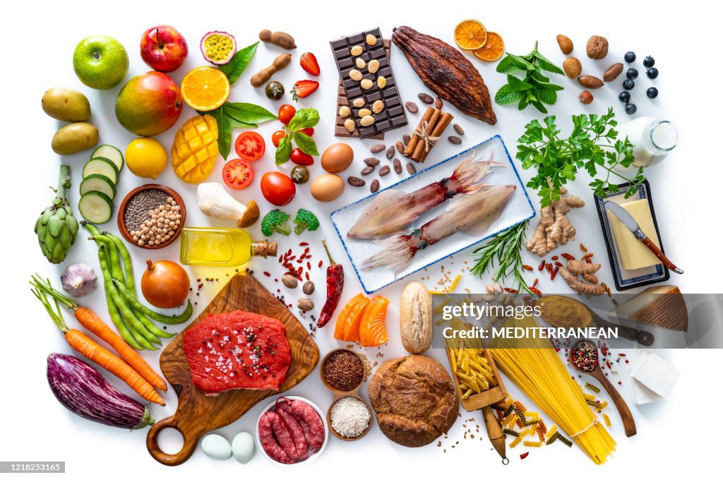 Varied food carbohydrates protein vegetables fruits dairy legumes on white