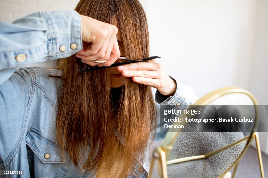 A woman cutting her own hair