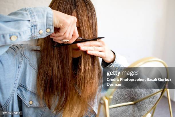 a woman cutting her own hair - bangs hair cut stock pictures, royalty-free photos & images