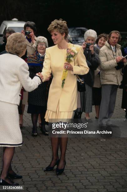 Diana, Princess of Wales visits a hospice in Windsor, UK, 27th January 1992. She is wearing a pale yellow suit by Catherine Walker and a Chanel...