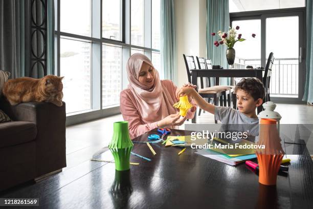 mother and child are making decorations for ramadan - arab student kids photos et images de collection