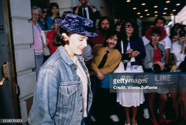 American singer and actress Madonna wearing a purple velvet hat as she leaves a theatre on Broadway, New York City, circa 1988.