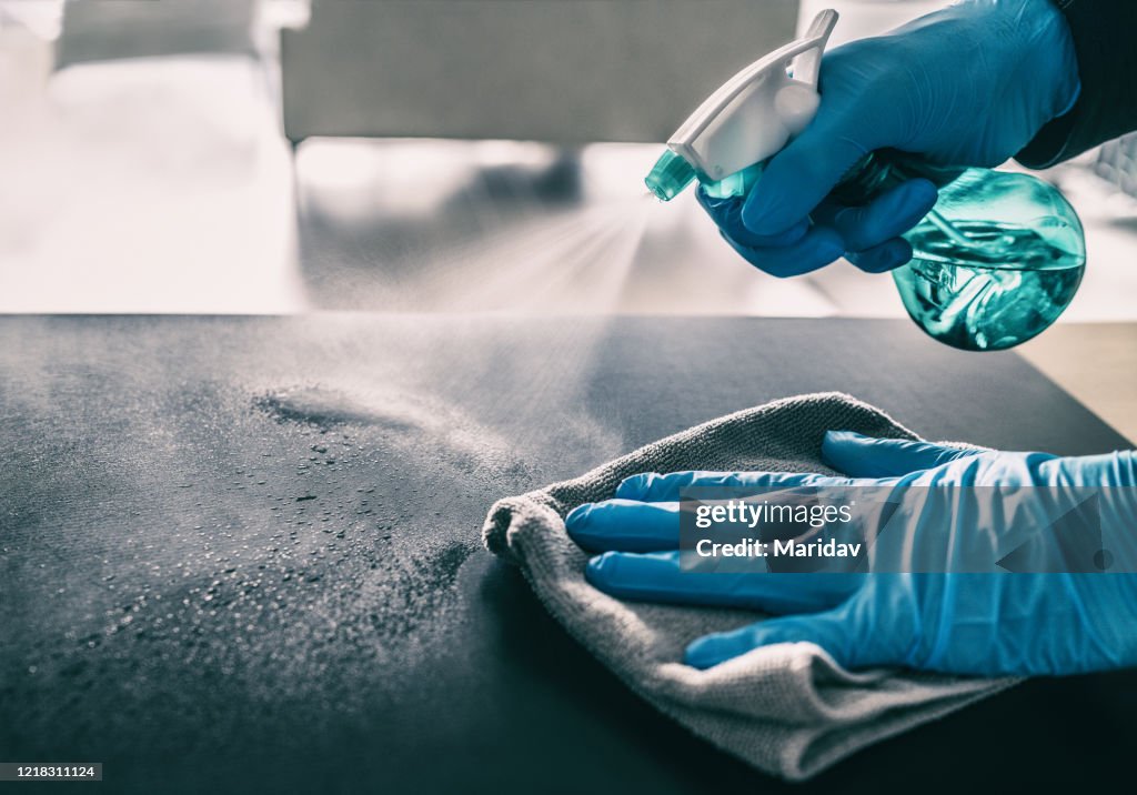針對 COVID-19 疫情進行表面消毒。家庭清潔噴灑抗菌噴霧瓶消毒對冠狀病毒戴手套。消毒醫院表面預防