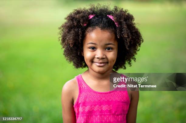 portrait of cute charming adorable afro childhood smiling and looking at camera. - afro hairstyle stock pictures, royalty-free photos & images