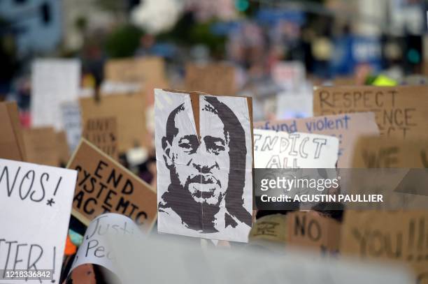 Protesters march holding placards and a portrait of George Floyd during a demonstration against racism and police brutality, in Hollywood, California...