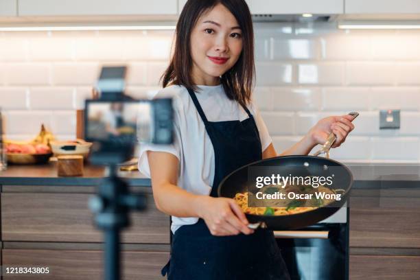 young woman vlogging cooking at home - food demonstration stock pictures, royalty-free photos & images