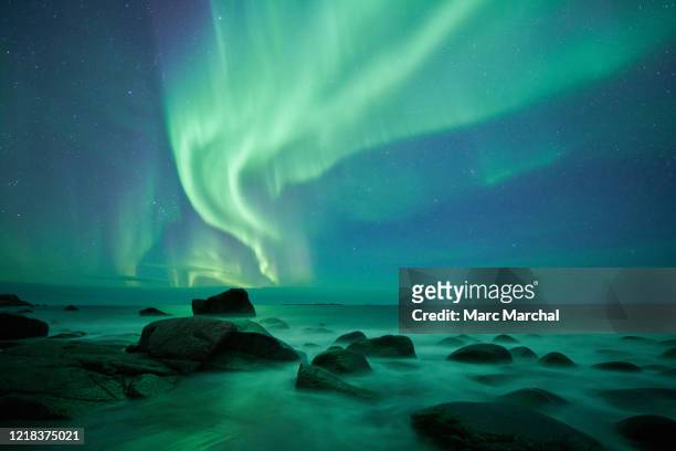 aurora borealis over uttakleiv beach - aurora borealis fotografías e imágenes de stock