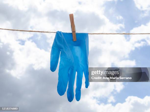 gloves hang out on a clothesline rope against a sky with storm clouds - rope lava stock pictures, royalty-free photos & images