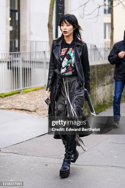 Guest wears a black leather jacket, a David Bowie t-shirt, a black leather skirt, black leather thigh-high boots, during Paris Fashion Week -...