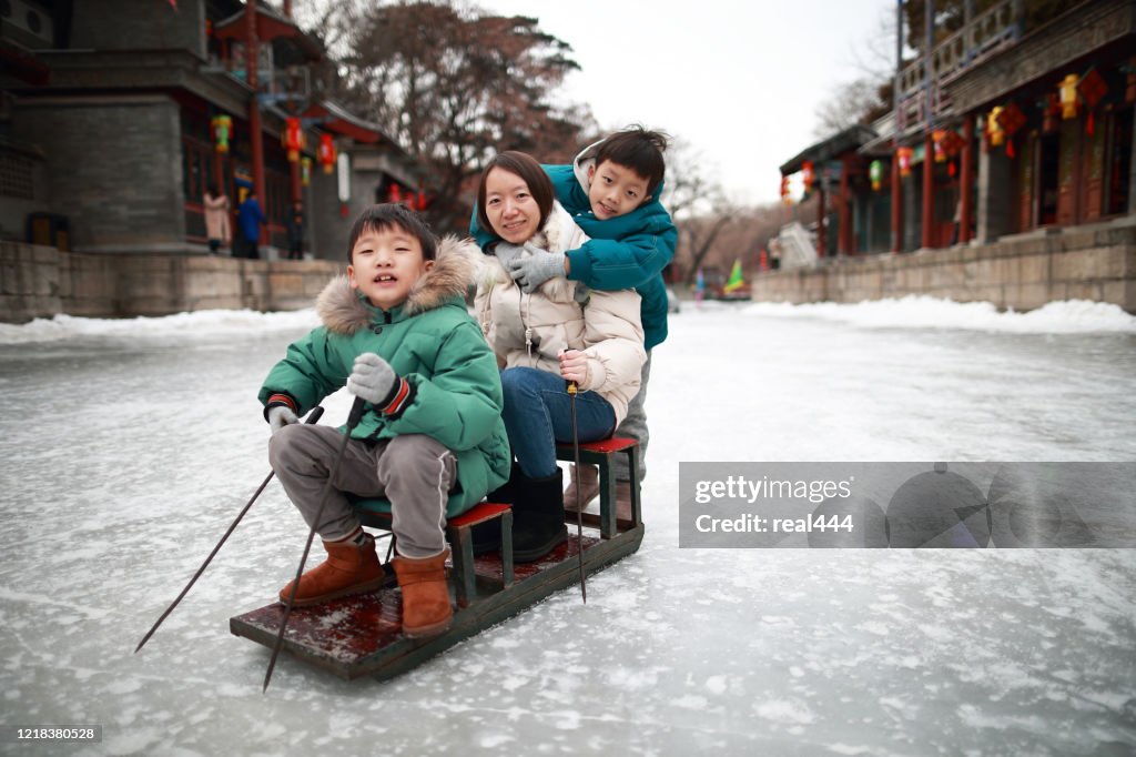 Child on the lake freezes to enjoy sledding, ice skate, ice bike at Summer Palace in Beijing in Winter,