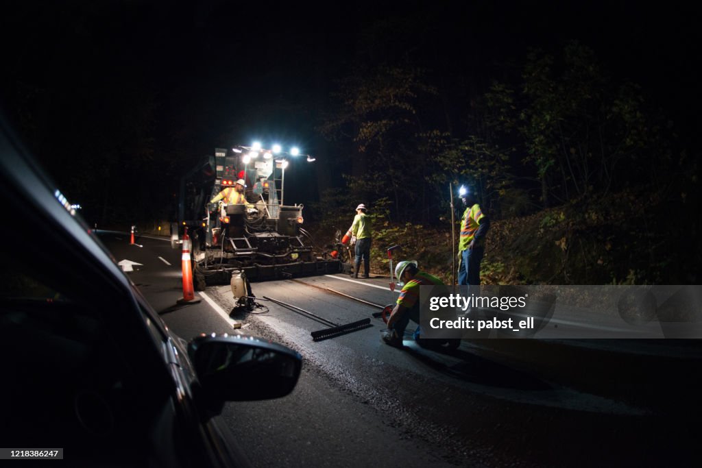 Men working on tarmac road maintenance at night Yosemite essential service