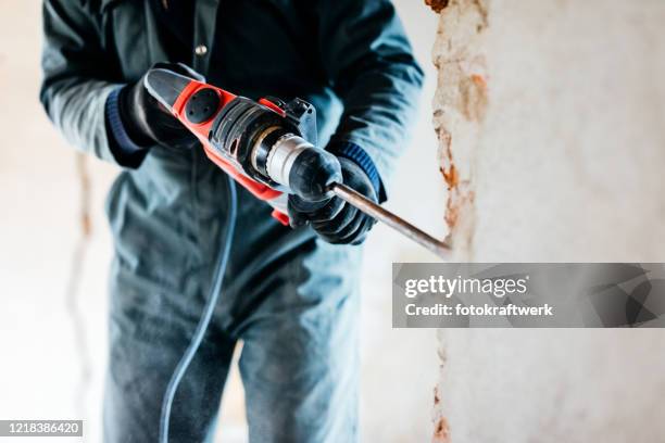 arbeiter mit pneumatischen hammerbohrer, um die wand betonziegel zu schneiden, nahaufnahme - baustelle beton stock-fotos und bilder