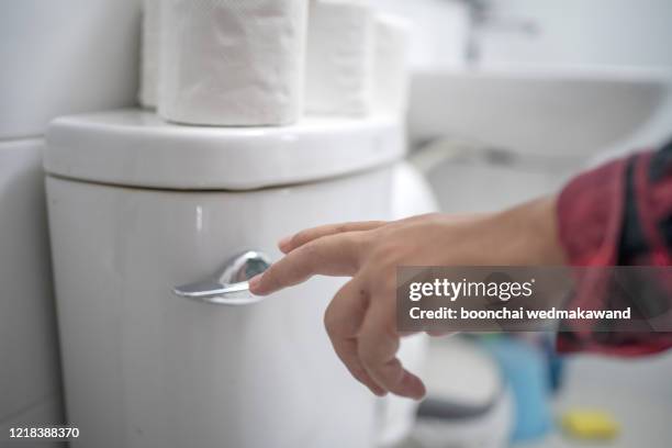 finger pushing button flushing toilet - flushing stock pictures, royalty-free photos & images