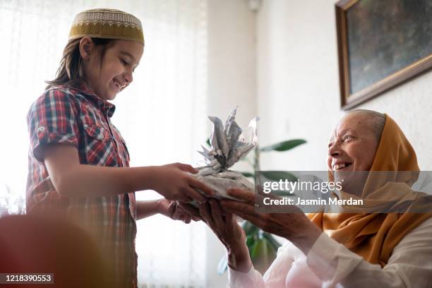 kid traditionally kissing parent's hand as a sign of respect - two young arabic children only indoor portrait stock-fotos und bilder