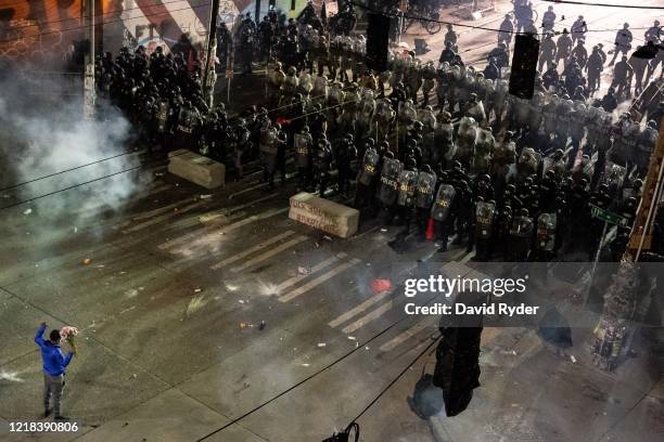 Person holds flowers as demonstrators clash with police near the Seattle Police Departments East Precinct shortly after midnight on June 8, 2020 in...