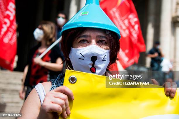 Woman wearing a funnel on her head holds a banner during a demonstration of major teachers' trade unions in front of the Ministry of Education on...