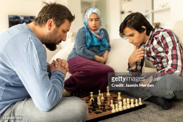 traditional family playing chess during day in ramadan - american muslims celebrate eid al fitr with prayers foto e immagini stock