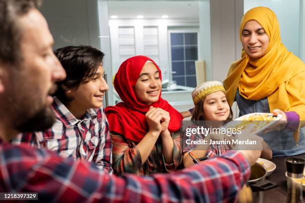 muslim family gathering for iftar after sunset in ramadan - eid al fitr celebration to mark the end of ramadan stockfoto's en -beelden