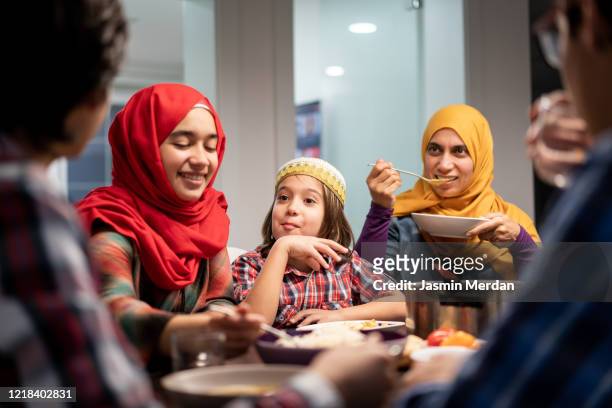 family eating iftar and enjoying breaking of fasting - religious service stock-fotos und bilder