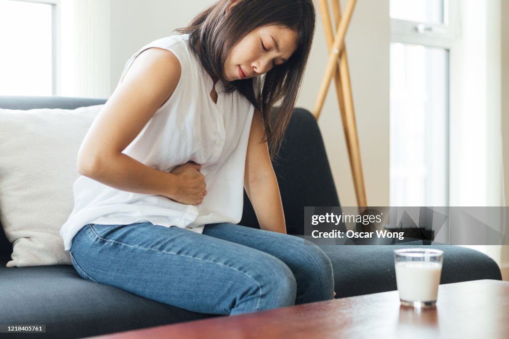 Young Woman Suffering Stomach At Home