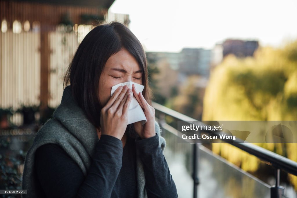 Sick Young Woman Blowing Nose