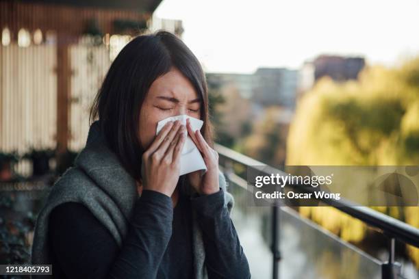 sick young woman blowing nose - allergy stock pictures, royalty-free photos & images