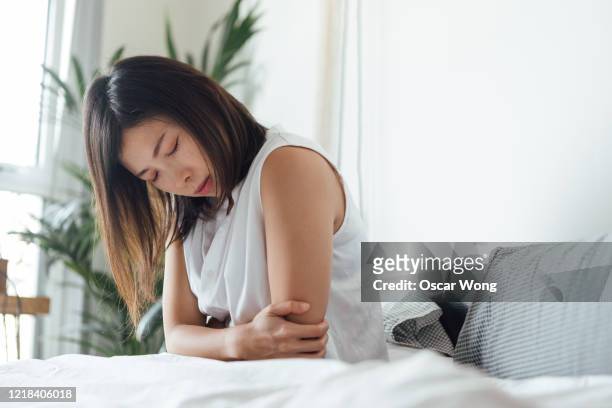 young woman suffering stomach in bed - indigestión fotografías e imágenes de stock