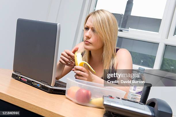busy woman eating a fruit salad work - david swallow stock pictures, royalty-free photos & images