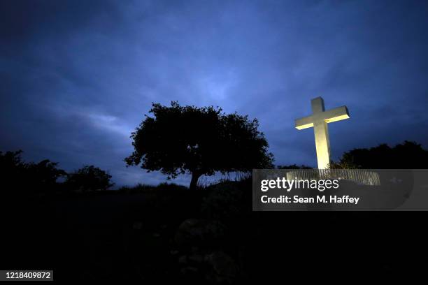 Large cross is lit up prior to a sunrise Easter service at Mt. Helix Park on April 12, 2020 in San Diego, California. Due to fears of the coronavirus...