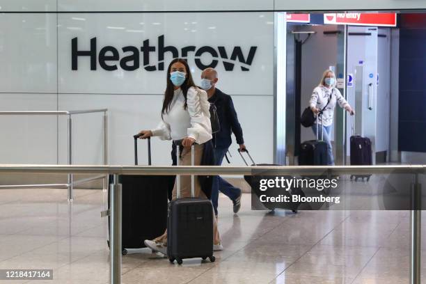 Passengers, wearing protective face masks, walk through the international arrivals hall after arriving at Terminal 2 at London Heathrow Airport in...