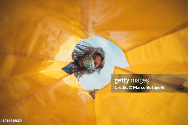 woman with face mask looking through an empty shopping bag - see through photos et images de collection